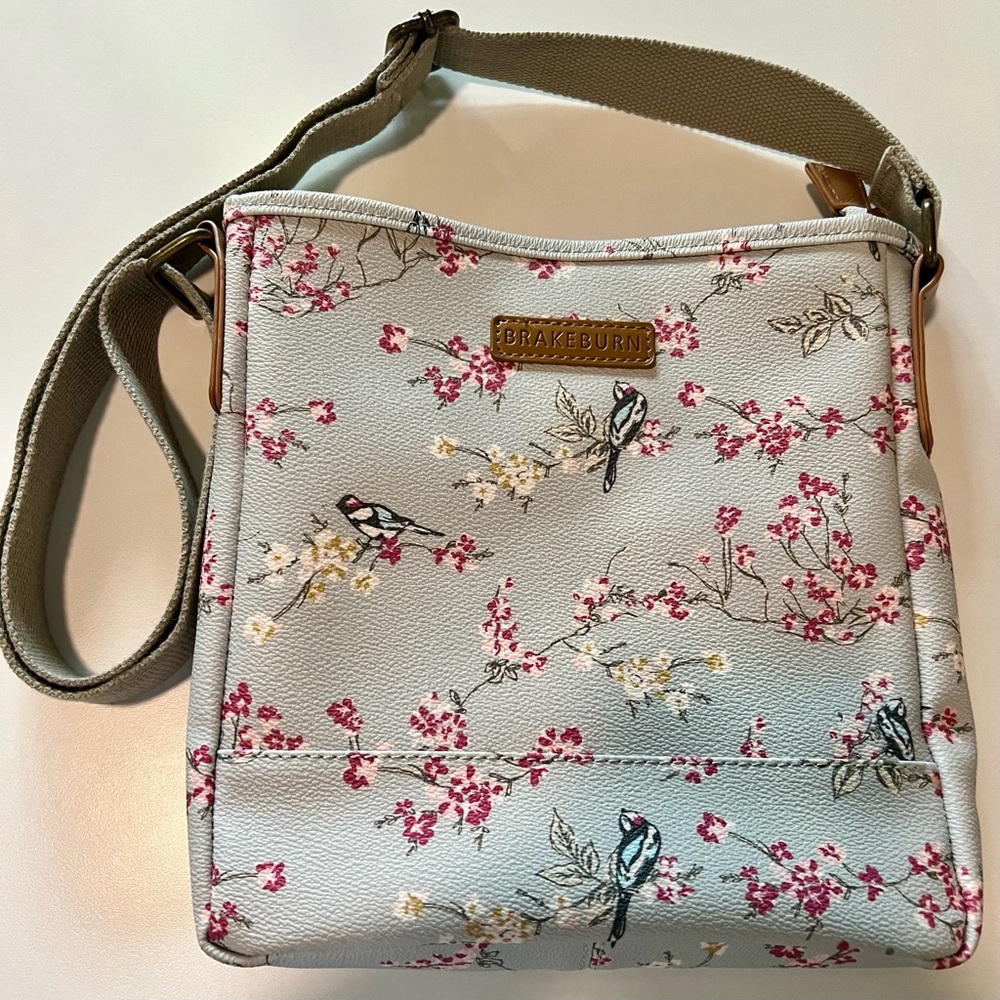 Brakeburn robin’s egg blue/gray cross body with a bird and a pink floral motif.